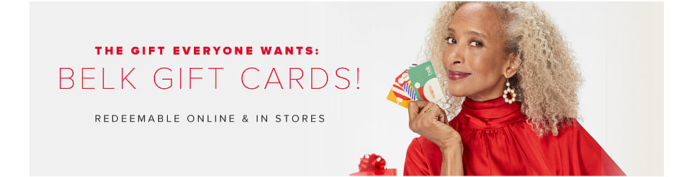 The gift everyone wants: Belk gift cards! Redeemable in stores & online. Image of woman holding gift cards.