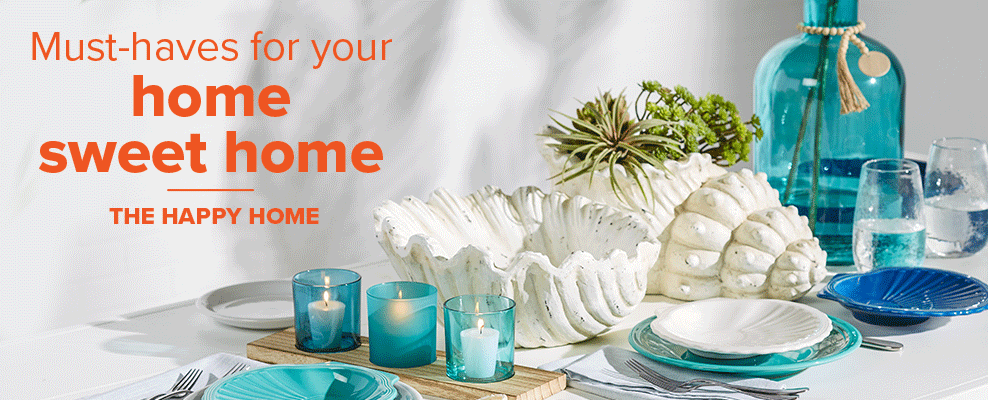 A dining table set up with various coastal decor, including a light blue vase with rope, white shell bowl and planter, three blue votive candles on a wooden plank, and blue and white dishes. Must-haves for your home sweet home. The happy home. 