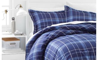 Image of blue checkered bed and white bedside table with lamp and basket