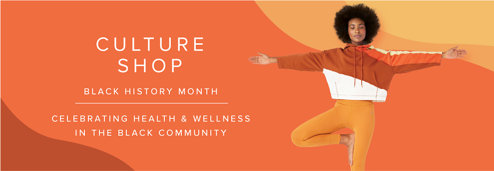 Black woman standing in a tree yoga pose wearing an abstract red, orange, yellow and white hoodie with orange yoga pants. Culture Shop: Black History Month. Celebrate this month's theme of health & wellness in the Black community