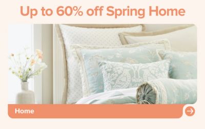 Up to 60% off spring home. A bed with light blue bedding. Shop home.