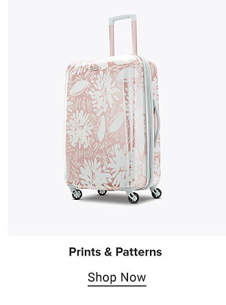 A rolling suitcase with a pink and white pattern. Prints and patterns. Shop Now.