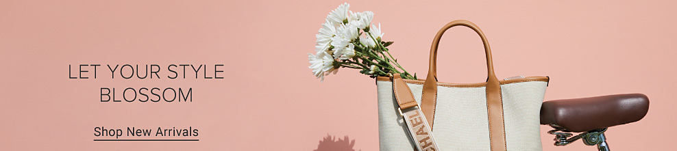 Image of a white handbag with a brown leather strap. Let your style blossom. Shop new arrivals. 