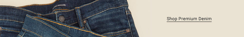 Waistbands of two pairs of jeans overlapped. Shop Premium Denim