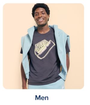 Shop men. A man in a tee shirt and blue sweatshirt and pants.