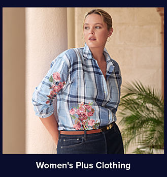 A woman in a blue plaid shirt with a floral design on it. Shop women's plus clothing. 