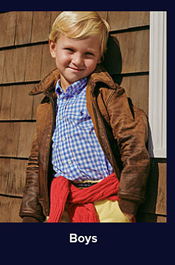 An image of a boy in a blue and white plaid shirt and brown jacket. Shop boys. 