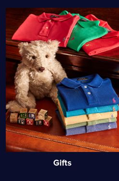 An image of folded polos and a Ralph Lauren teddy bear. Shop gifts. 