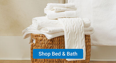 A stack of folded white towels. Shop bed and bath.