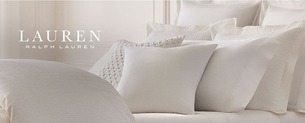 A bed with white pillows on it. Lauren Ralph Lauren.