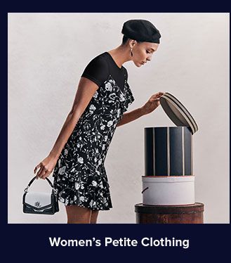 A woman in a black dress peeking into a black round box. Shop women's petite clothing.