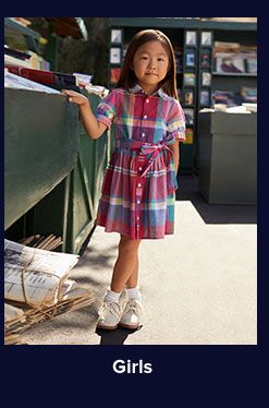 A girl in a red, white and blue plaid dress. Shop girls.