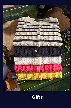 A stack of folded corded sweaters in a variety of colors. Shop gifts.