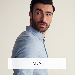 An image of a man wearing a light blue button up shirt. Shop men. 