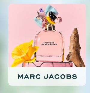 Shop Marc Jacobs. Perfume bottle on a pink stand next to flowers.