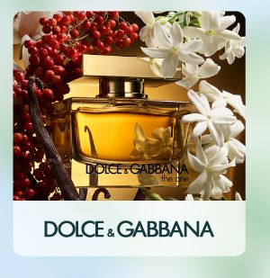 Shop Dolce and Gabbana. A perfume bottle surrounded by flowers.