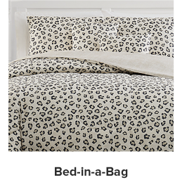 A bed with a white, brown and black leopard print comforter and pillows to match. Shop bed in a bag.