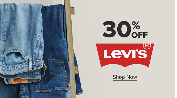 Levi's jeans hanging on a rack. 30% off Levi's. Shop now.