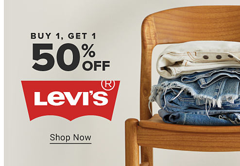 Image of a stack of pants on a chair. Buy 1, get 1 50% off Levi's. Shop Now.