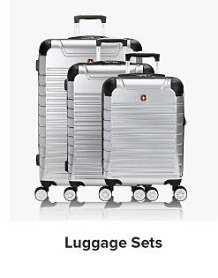 A trio of silver hardsided suitcases. Shop luggage sets.