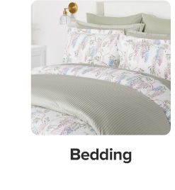 An image of a bed with a comforter and pillows to match. Bedding. 