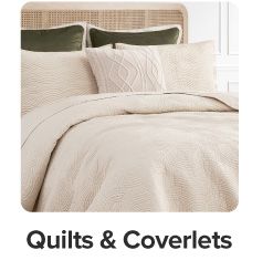 An image of a bed. Quilts and coverlets.