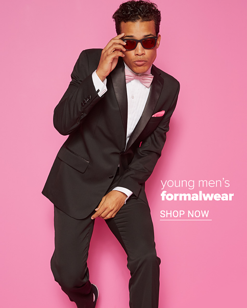 A young man in a black tuxedo, white dress shirt and pink bow tie. Young men's formalwear. Shop now.