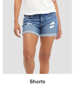 A woman in a white tee and distressed shorts. Shorts.