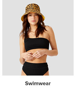 A woman in a leopard bucket hat and a black bikini. Swimwear.