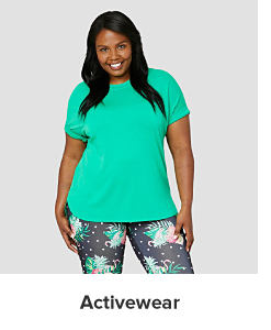 A woman in a green tee and patterned leggings. Activewear. 