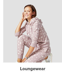 A woman in a matching polka dot mauve hoodie and pant set. Loungewear.
