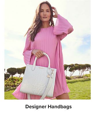 Image of woman in pink dress with handbag. Shop Designer Handbags.