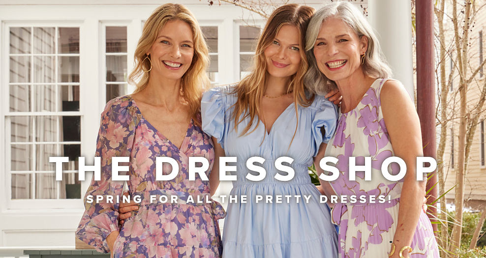 An image of a woman wearing a floral dress standing next to a women wearing a chambray dress and another women wearing a sleeveless floral dress. The dress shop. Spring for all the pretty dresses.