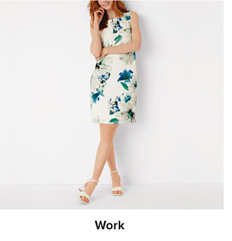 An image of a woman wearing a white floral dress. Shop work dresses.