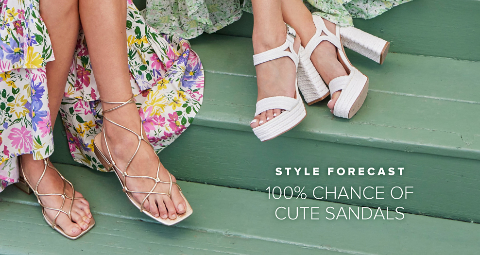 An image of two women sitting on steps showing off their sandals. One woman is wearing flat sandals with straps and the other is wearing white platform block heel sandals. Style forecast, 100% chance of cute sandals.