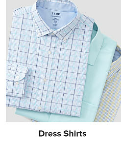 Image of a stack of button up shirts. Shop dress shirts.