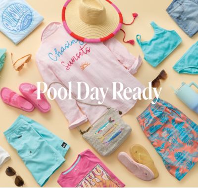 Pool day ready. A bunch of warm weather clothes and accessories placed on. A table.