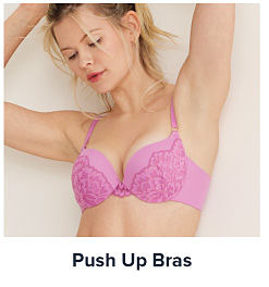 Image of a woman wearing a bright pink bra. Shop push up bras.