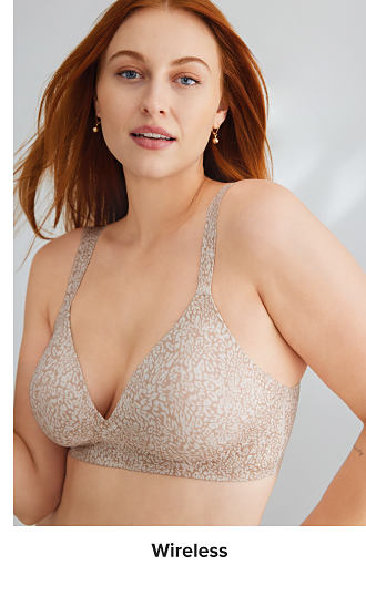 An image of a woman wearing a beige and white wireless bra. Shop wireless.