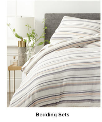Image of a bed made in a striped set. Shop bedding sets.
