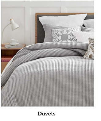 Image of a made bed. Shop duvets.