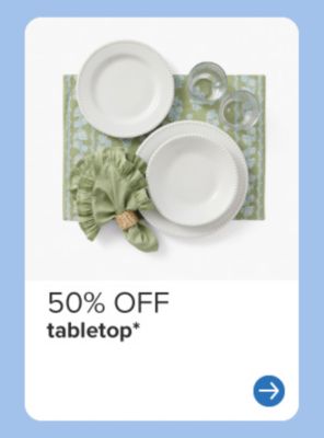 White dinnerware on a green place setting. 50% off tabletop.