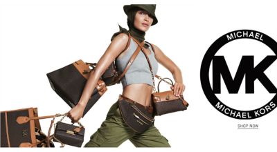 A woman wearing an olive green bucket hat, a black head scarf, a gray sports bra & olive green pants, carrying several different styles of handbags. Michael Michael Kors. Shop now.