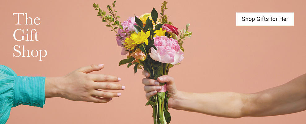 An image featuring a person handing their mom a bouquet of flowers. The gift shop. Shop gifts for her.