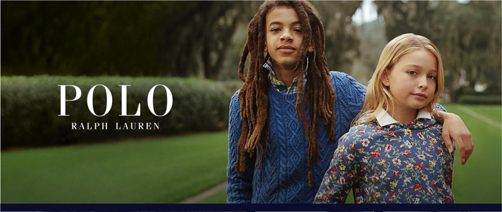 Young boy wearing a blue sweater over a collared shirt. Young girl wearing a floral sweater over a collard shirt. Polo Ralph Lauren. 