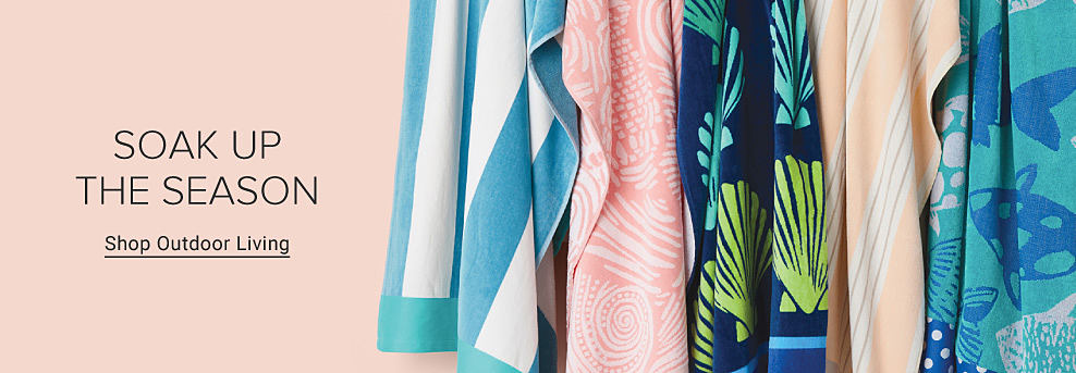 Beach towels hanging from a rack. Soak up the season. Shop outdoor living.