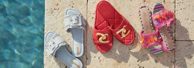 An image of three pairs of sandals by a swimming pool