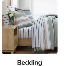 An image of a bed with striped bedding. Bedding.