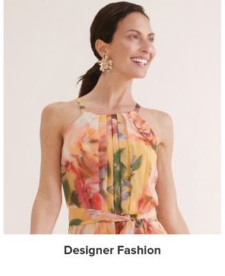 An image of a woman wearing a floral dress. Shop designer fashion