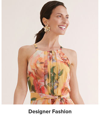 An image of a woman wearing a floral dress. Shop designer fashion